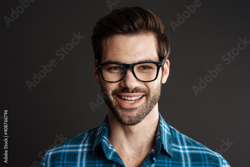 Smiling brutal guy in eyeglasses posing on camera