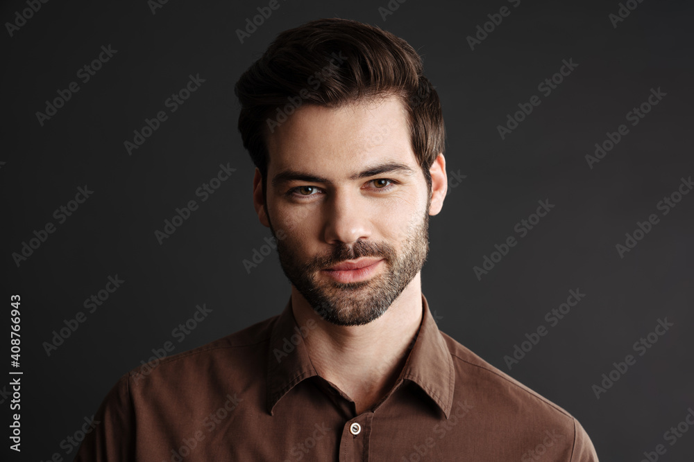 Obraz premium Pleased handsome unshaven guy posing and looking aside