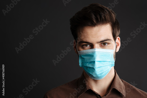 Caucasian handsome young man posing in protective mask