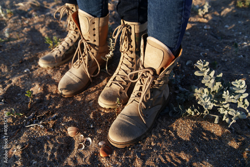 Woman and man in army beige boots spend outdoor activities in the wilderness