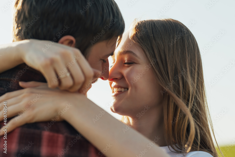Close up portrait of a beautiful young caucasian couple hugging and smiling while dating.