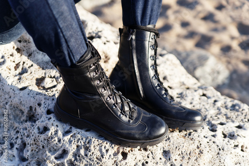 Black boots in eco-style style with eco-leather on laces for active tourism in the mountains or forest