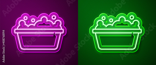 Glowing neon line Baby bathtub with foam bubbles inside icon isolated on purple and green background. Vector.