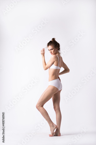 Woman body beauty full length in lingerie posing on a white background.