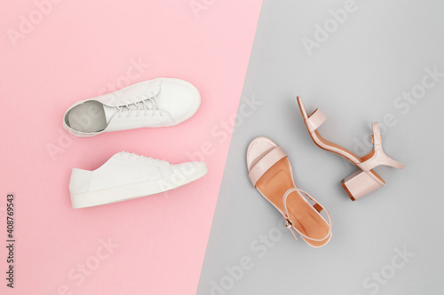 White sneakers and pink heeled sandals on grey and pink paper background. Stylish spring or summer woman's shoes in pastel colors. Trendy beauty female fashion background. Flat lay, top view.