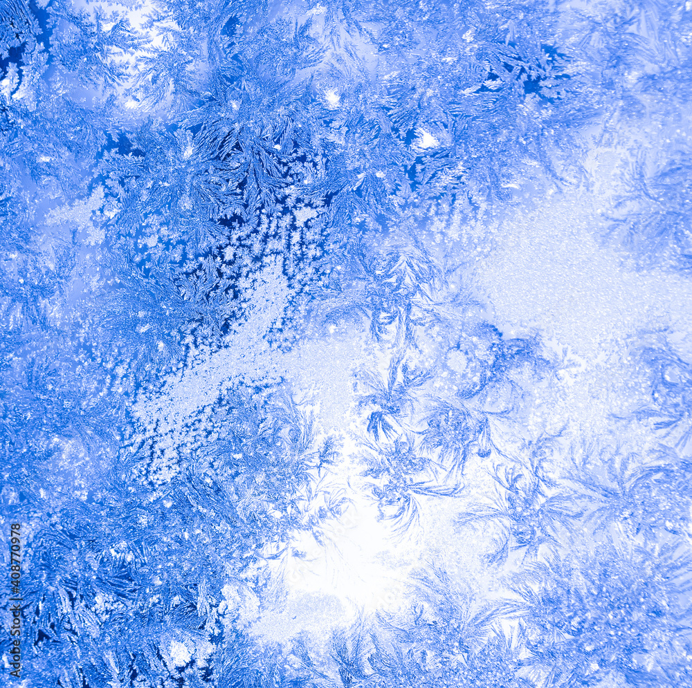 blue texture of frost ice surface with frozen design tracery ,cold cryslallized surface background ,winter glass side close up , abstract macro wallpaper