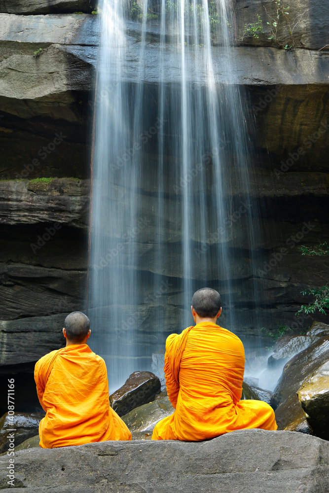 Monks doing meditation in front of a waterfall in thailand Monks doing meditation in front of a waterfall in thailand