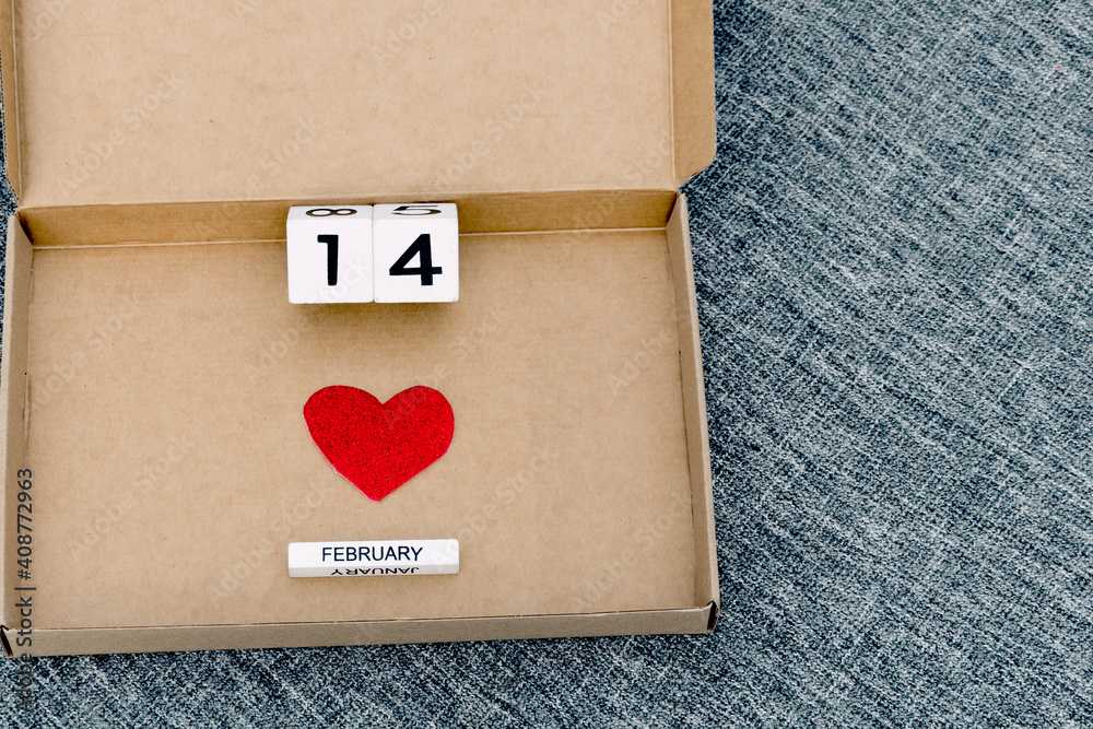 Happy Valentines Day, love delivery, cardboard box with heart symbol and 14 February date , gray textile background, valentine at home Happy Valentines Day, love delivery, cardboard box with heart symbol and 14 February date , gray textile background, valentine at home
