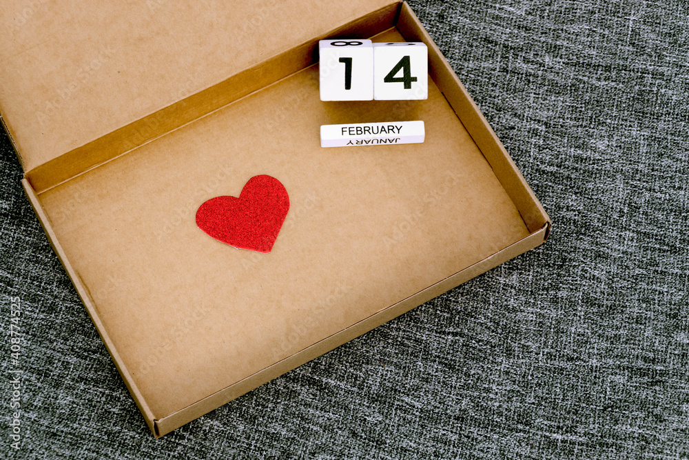 Happy Valentines Day, love delivery, cardboard box with heart symbol and 14 February date , gray textile background, valentine at home Happy Valentines Day, love delivery, cardboard box with heart symbol and 14 February date , gray textile background, valentine at home