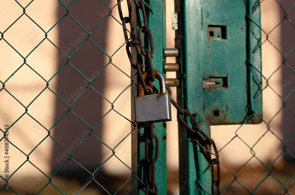 Padlock. Steel chain. Closed gate. Metal grid. Padlock. Steel chain. Closed gate. Metal grid.