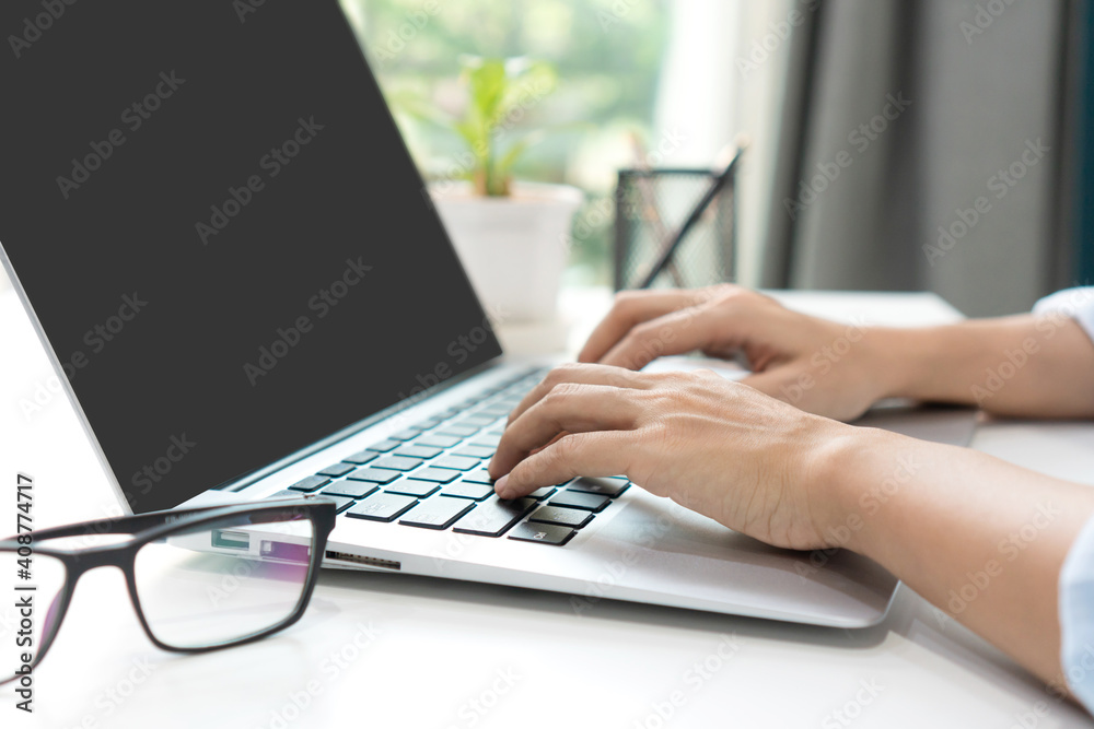Asian woman freelancer is working on a new project on laptop computer with blank copy space screen for your advertising text message at home. Work from home, business and technology concept. Closeup Asian woman freelancer is working on a new project on laptop computer with blank copy space screen for your advertising text message at home. Work from home, business and technology concept. Closeup