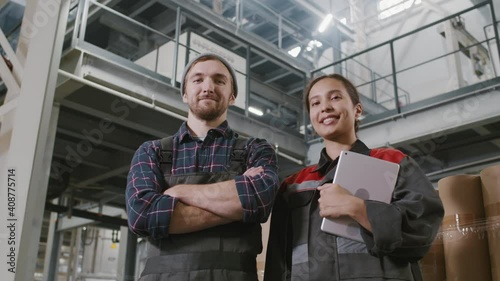 Wallpaper Mural Low-angle medium slowmo close-up portrait of smiling man and woman in coverall uniform working at polyethylene factory together Torontodigital.ca
