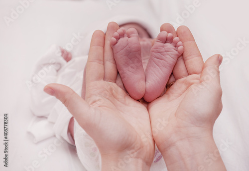 Mother holding her little baby's feet, close up.Concept skin examination by a doctor