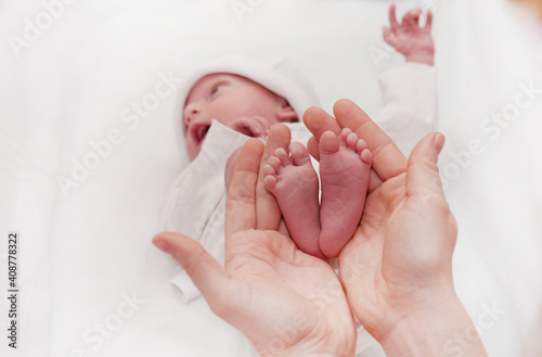 Photography Mother holding her little baby's feet, close up