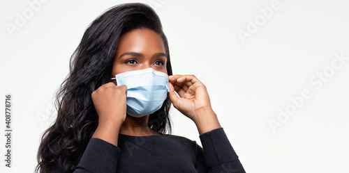 African-American woman adjust her mask for a proper fit 0335 - extended landscape version photo