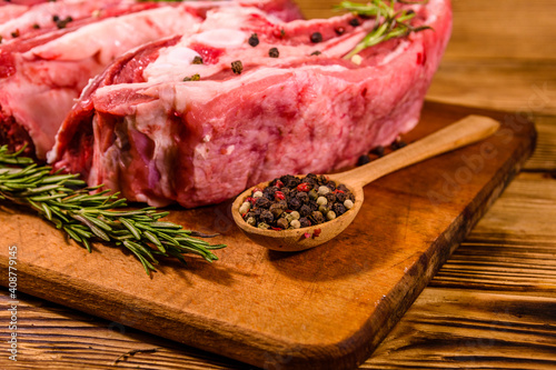 Raw pork ribs with spices and rosemary on a cutting board