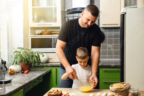 Foto Caring father teaches his son to cook