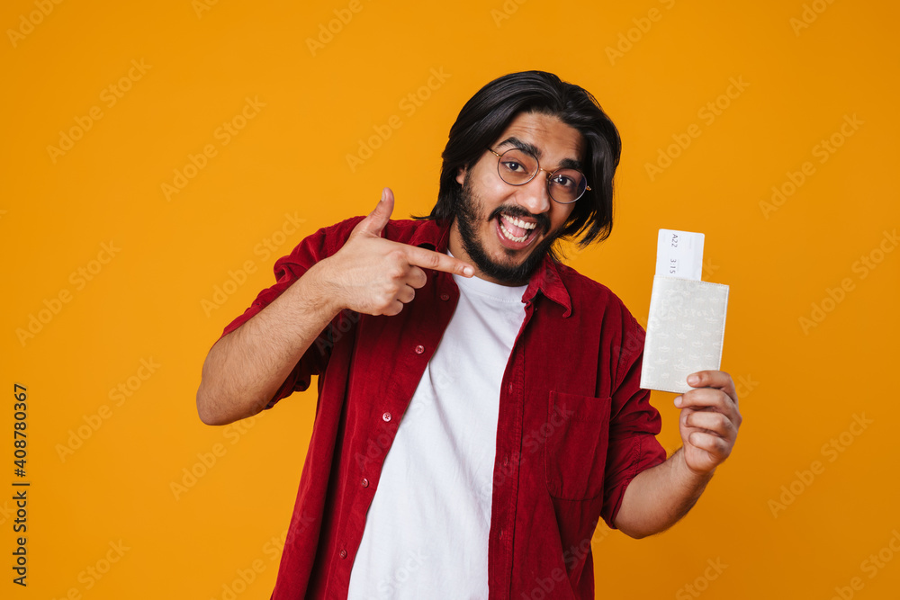 Cheerful young indian man showing flight ticckets Cheerful young indian man showing flight ticckets