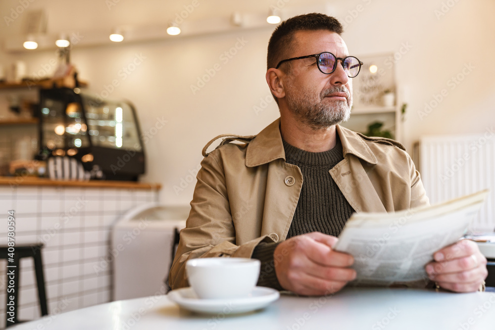 Handsome confident businessman reading newspaper Handsome confident businessman reading newspaper