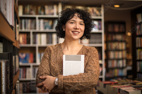 Woman in library holding book. 
