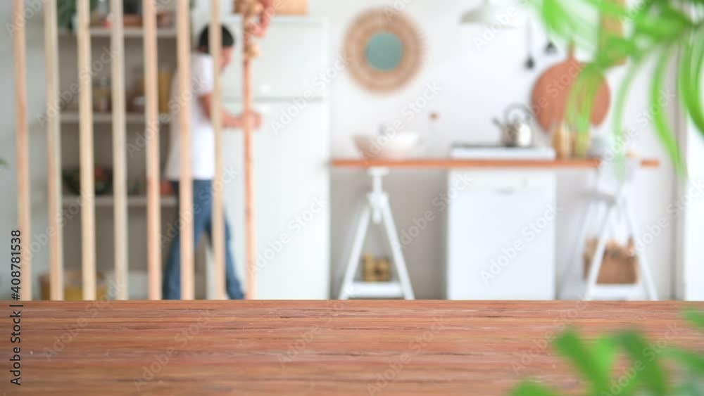 Kitchen close up wood table and blur background, man is drink coffee and washing dishes. Kitchen close up wood table and blur background, man is drink coffee and washing dishes.