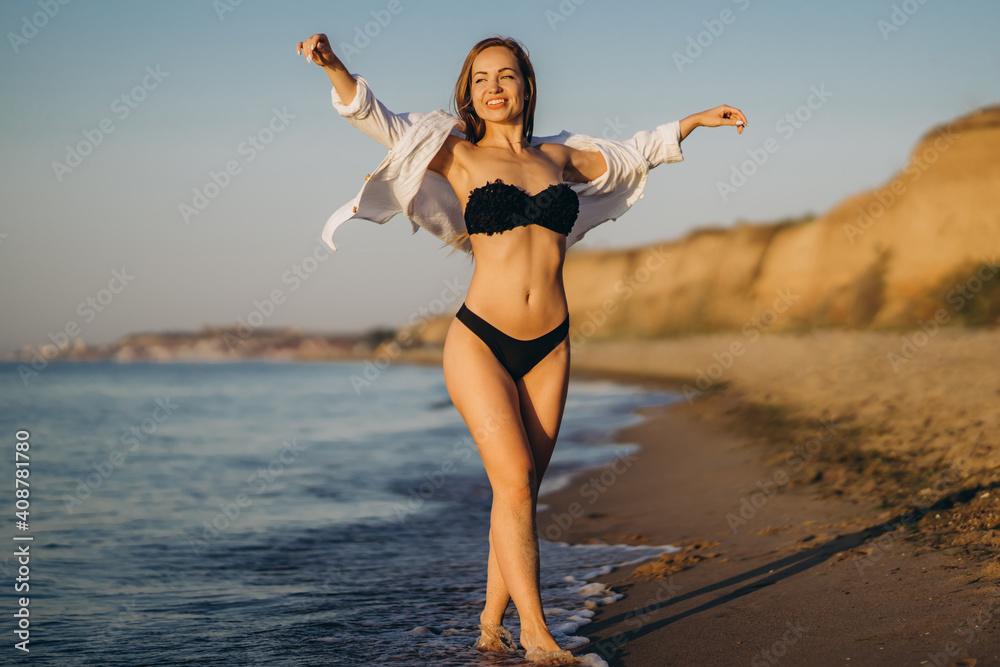 Naklejka premium Pretty brunette woman relaxing on the beach at the sea.