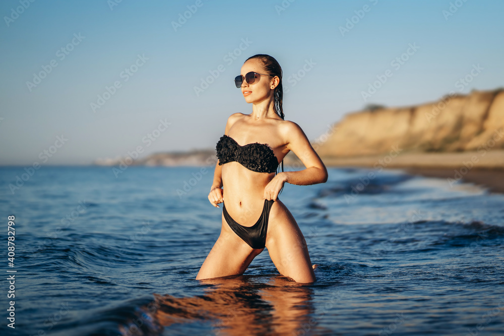 Pretty brunette woman relaxing on the beach at the sea. Pretty brunette woman relaxing on the beach at the sea.