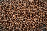 top view of many freshly roasted coffee beans on black background