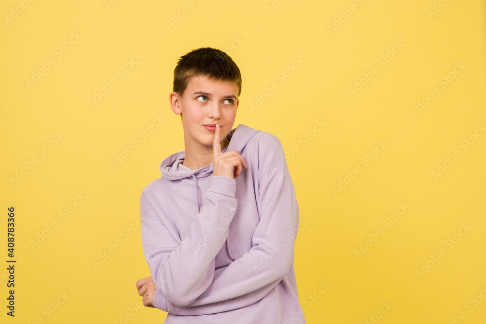 Thinking, dreaming. Caucasian girl's portrait isolated on yellow background with copyspace. Beautiful female model in hoodie. Concept of human emotions, facial expression, sales, ad, fashion.
