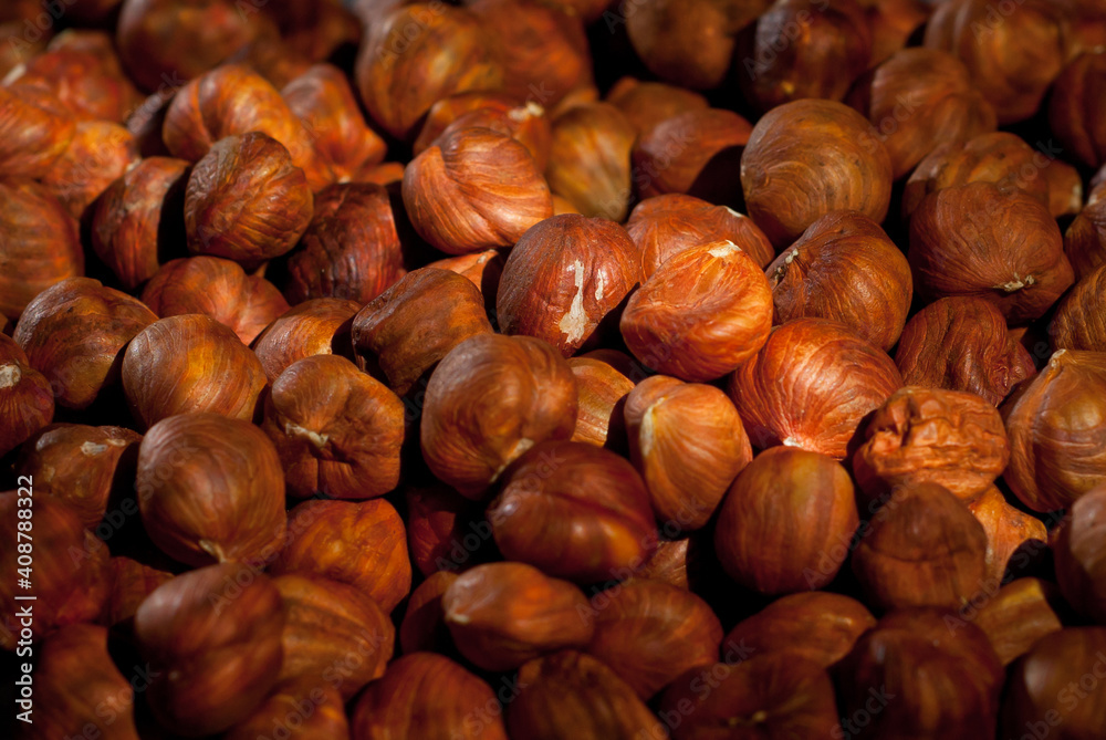 Peeled hazelnuts close up. Texture of nuts. Lots of nuts in a pile. Contrasting dramatic light as an artistic effect. Peeled hazelnuts close up. Texture of nuts. Lots of nuts in a pile. Contrasting dramatic light as an artistic effect.