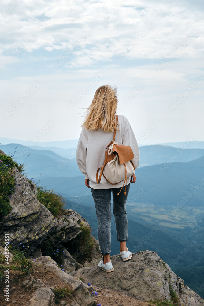 Naklejka premium Girl enjoy scenics view on valley. Beautiful nature landscape in mountains. Hiking journey on tourist trail. Outdoor adventure. Travel and exploration. Healthy lifestyle, leisure activities