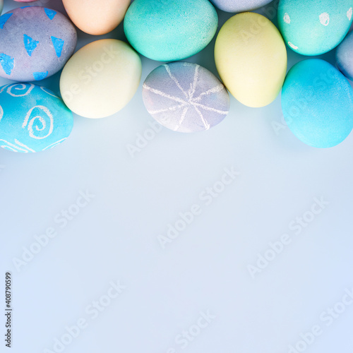 Canvas Print Colorful Easter decorated eggs on bright blue table background.