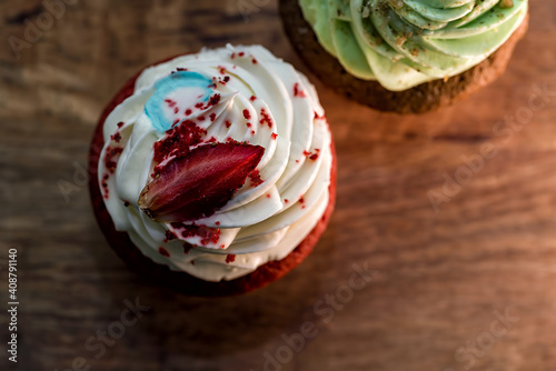 red cupcake with white cream on a dark background