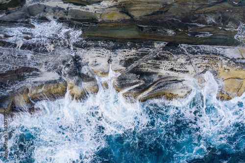 Aerial shot of Pacific waves surging onto rocky outcrop along the coastline of Biri Island photo