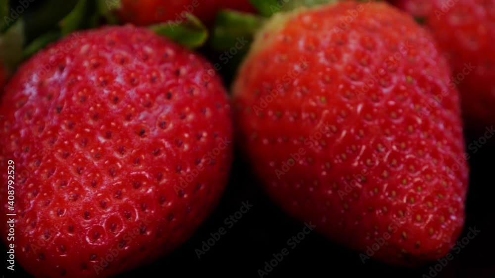 Strawberries rotating on a black background close up, view. Fresh, organic vibrant red strawberry in 4K. Raw vegan summer snack. Strawberries rotating on a black background close up, view. Fresh, organic vibrant red strawberry in 4K. Raw vegan summer snack.