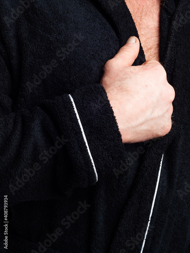 man in a bright, bath robe advertises clothing details on an isolated white background.