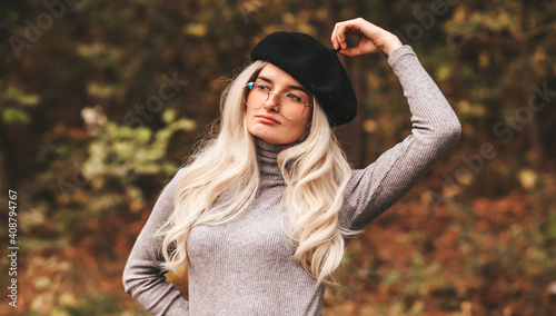 Stylish blonde girl in a cute black beret and glasses 