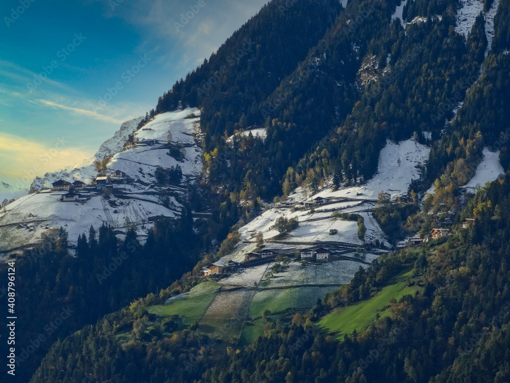 Blick von Schenna in Südtirol auf die Bergwiesen mit Häusern auf der gegenüberliegenden Seite