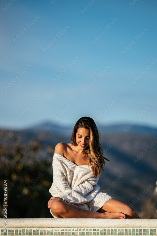 Happy woman resting in yard against mountains