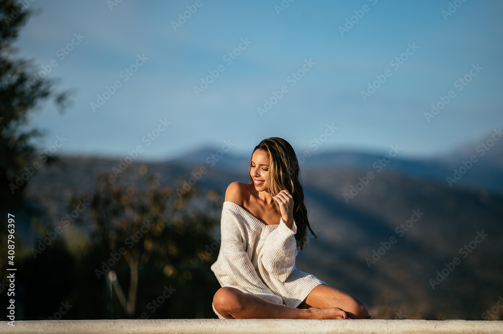 Happy woman resting in yard against mountains