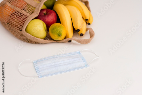 Shopping bag with fruits during quarantine and a protective mask. Zero waste, plastic free concept.