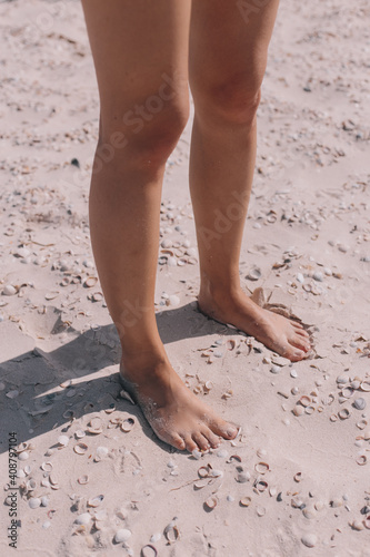Female feet on the beach on the sand