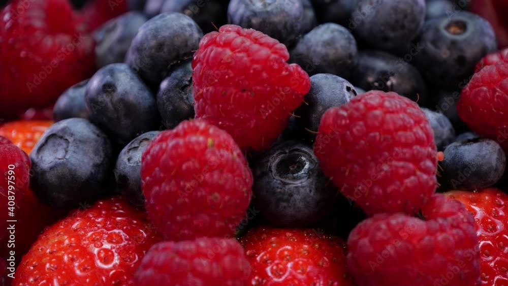 Raspberries, strawberries and blueberries rotating on a black background close up, view. Fresh, firm and tasty berries with mint in 4K. Raw vegan summer snacks, forest berries. Raspberries, strawberries and blueberries rotating on a black background close up, view. Fresh, firm and tasty berries with mint in 4K. Raw vegan summer snacks, forest berries.