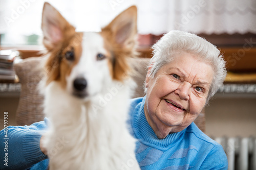 portrait of a senior adult woman holding a half breed dog on her lap
