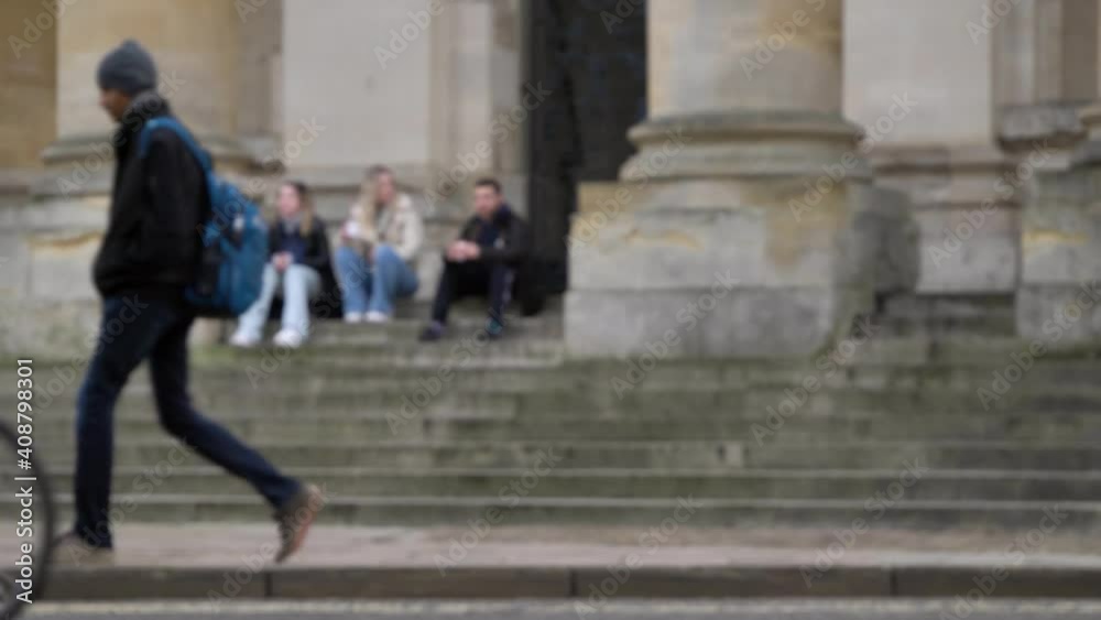 Defocused Wide Shot of People Sitting On Steps of Clarendon Building as Pedestrians Walk Past Defocused Wide Shot of People Sitting On Steps of Clarendon Building as Pedestrians Walk Past