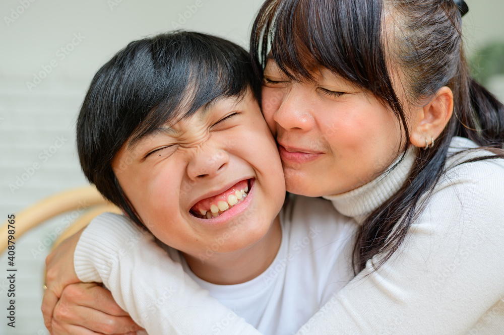 Happy mother embracing and kissing her son Happy mother embracing and kissing her son