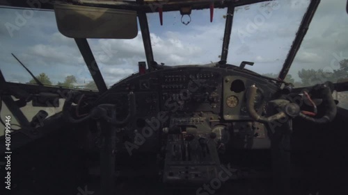 Inside view military abandoned plane cabin dusty dashboard cockpit interior. Control panel cargo helicopter standing on runway without pilot. photo