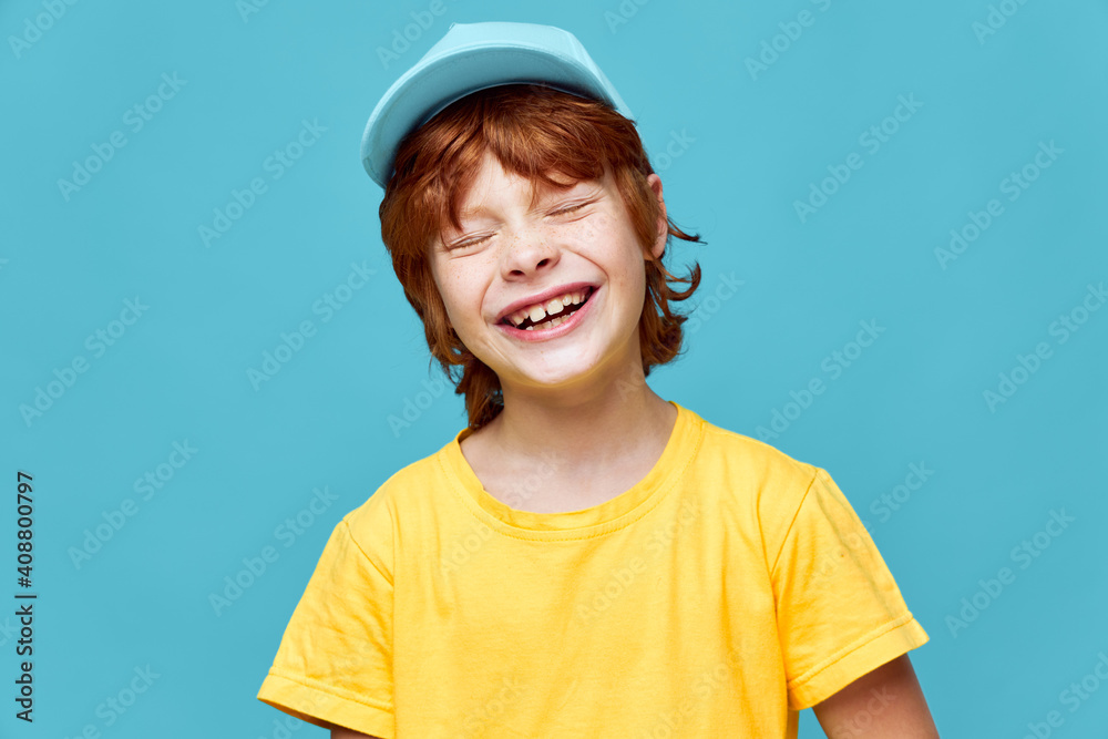 Cheerful red-haired boy yellow t-shirt smile closed eyes Cheerful red-haired boy yellow t-shirt smile closed eyes