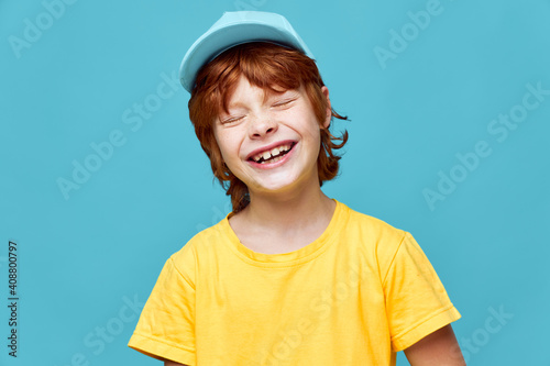 Cheerful red-haired boy yellow t-shirt smile closed eyes 