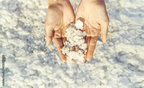 Top view woman hands holding crystallized salt natural mineral formation at Dead Sea coastline with highlight sunlight © vitaliymateha
